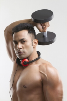 man posing with dumbbells and headphones