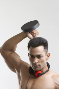 man posing with dumbbells and headphones