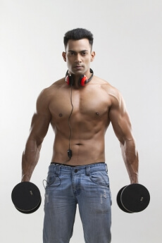 man posing with dumbbells and headphones