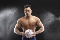 muscle man posing with a sports ball