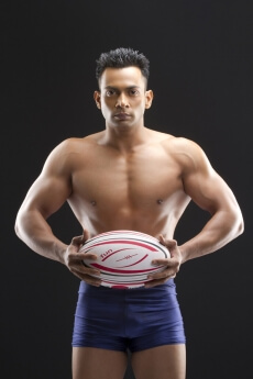 muscle man posing with a sports ball