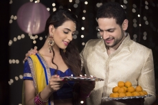 husband and wife with ladoo and thaali