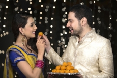 husband feeding ladoo to wife 
