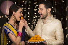 husband feeding ladoo to wife 