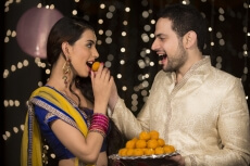 husband feeding ladoo to wife 