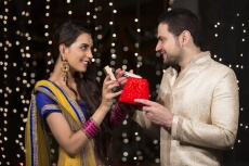 woman giving mobile phone as diwali gift to her husband 