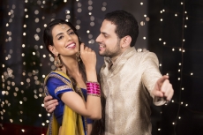 couple in traditional wear pointing towards something 