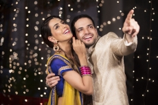 couple in traditional wear pointing towards something 