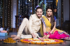 couple sitting and making rangoli on diwali