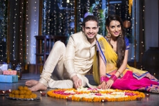 couple sitting and making rangoli on diwali