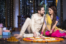 couple sitting and making rangoli on diwali