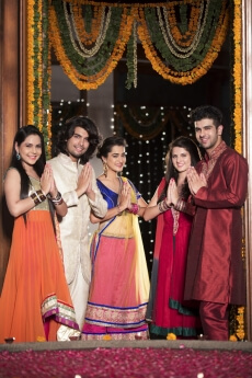 couples with folded hands standing at entrance gate on diwali