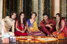 couple decorating home with flower rangoli