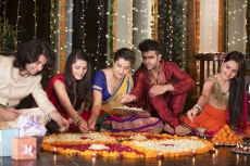couple decorating home with flower rangoli