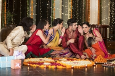 couple decorating home with flower rangoli and having fun 