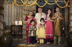 family standing at entrance gate to welcome