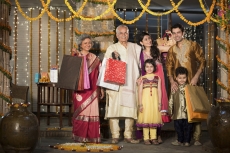 family with diwali gifts standing at entrance of house 