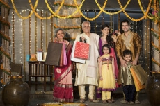 family with diwali gifts standing at entrance of house 