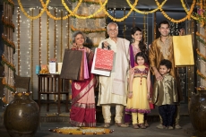 family with diwali gifts standing at entrance of house 