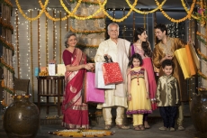 family with diwali gifts standing at entrance of house 