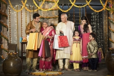 family with diwali gifts standing at entrance of house 