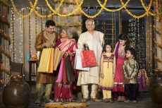 family with diwali gifts standing at entrance of house 