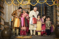 family with diwali gifts standing at entrance of house 