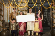 family standing at entrance with message board on diwali