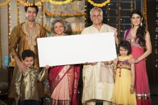 family standing at entrance with message board on diwali