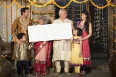 family standing at entrance with message board on diwali