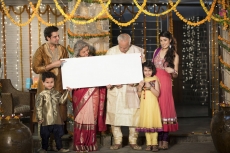 family standing at entrance with message board on diwali