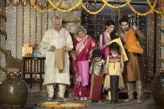 family in traditional wear standing with diwali gifts 