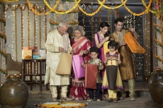 family in traditional wear standing with diwali gifts 