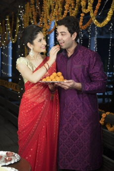 attractive young couple sharing diwali sweets