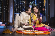 couple sitting and making rangoli on diwali