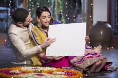 couple in traditional wear posing with a message board 