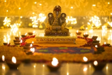 beautiful idol of ganesh placed against bright lights on diwali
