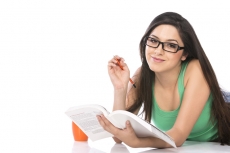 front view of a young teenage girl holding a pencil and a book