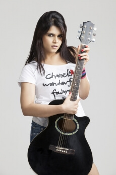 girl wearing short denims posing with a guitar