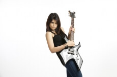 fashionable girl with an electric guitar playing hard-rock