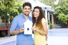couple showing home cutout outside villa 