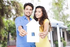 couple showing home shape paper cutout