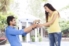 man gifting home miniature to woman