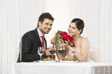 couple posing with bouquet on dinner table 