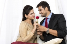 couple with rose looking at each other