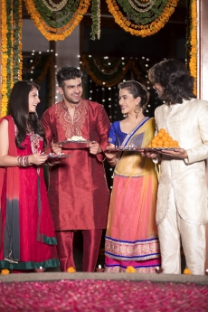 couple in traditional wear standing with thalis