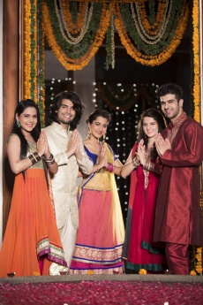couples with folded hands standing at entrance gate on diwali