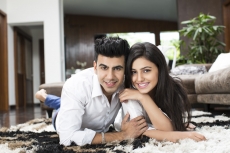 couple lying on rugs and looking at the camera while posing