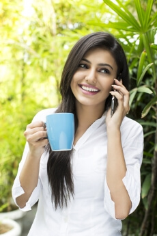 attractive female talking on the phone while having coffee