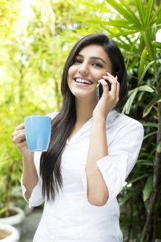 attractive female talking on the phone while having coffee